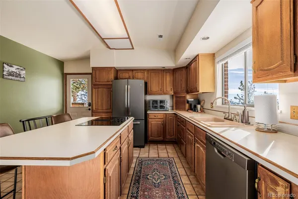 a kitchen with a sink a counter top space stainless steel appliances a window and a counter top space