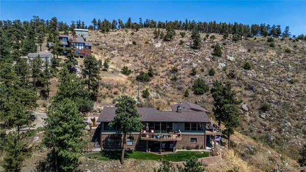 an aerial view of a house with swimming pool and outdoor seating