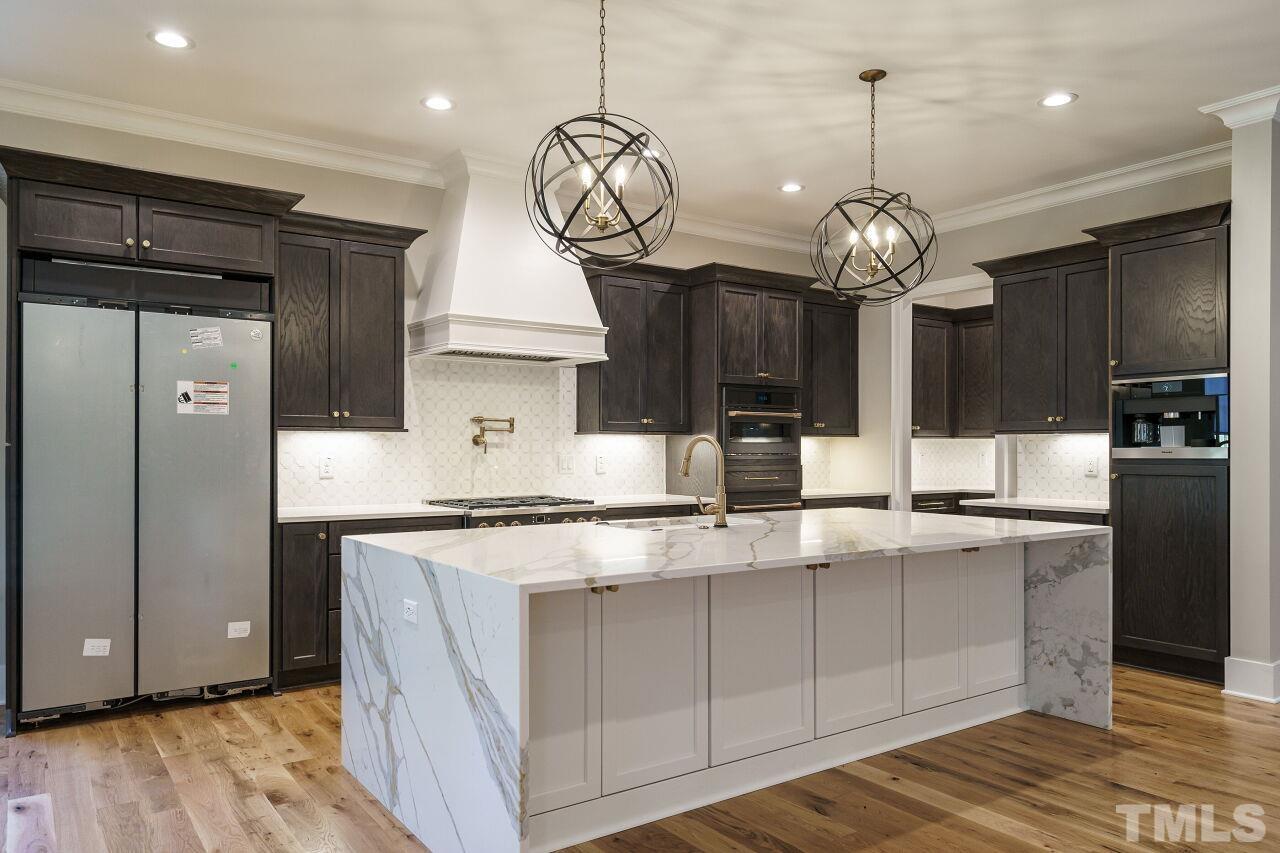 404 East Whitaker Mill Road Raleigh, NC 27608 - Photo 8 of 63 a kitchen with stainless steel appliances granite countertop cabinets a refrigerator and a wooden floor
