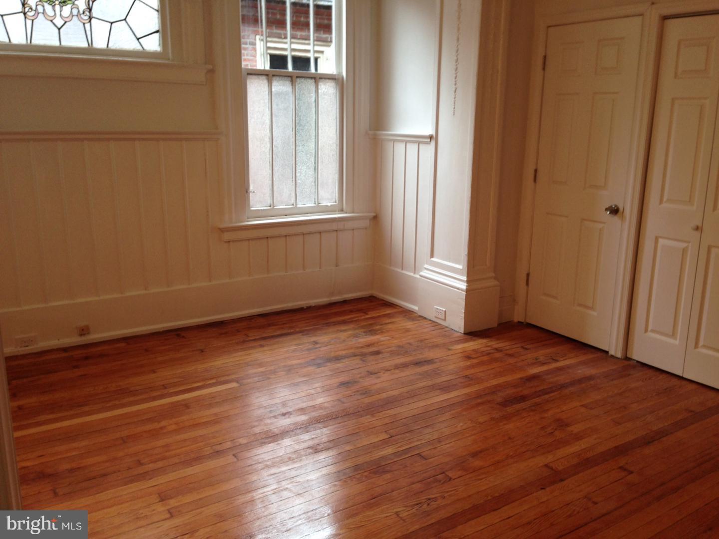 1209 Spruce Street, Unit 3R Philadelphia, PA 19107 - Photo 4 of 5 an empty room with wooden floor and windows