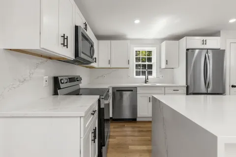 a kitchen with stainless steel appliances a sink stove and refrigerator