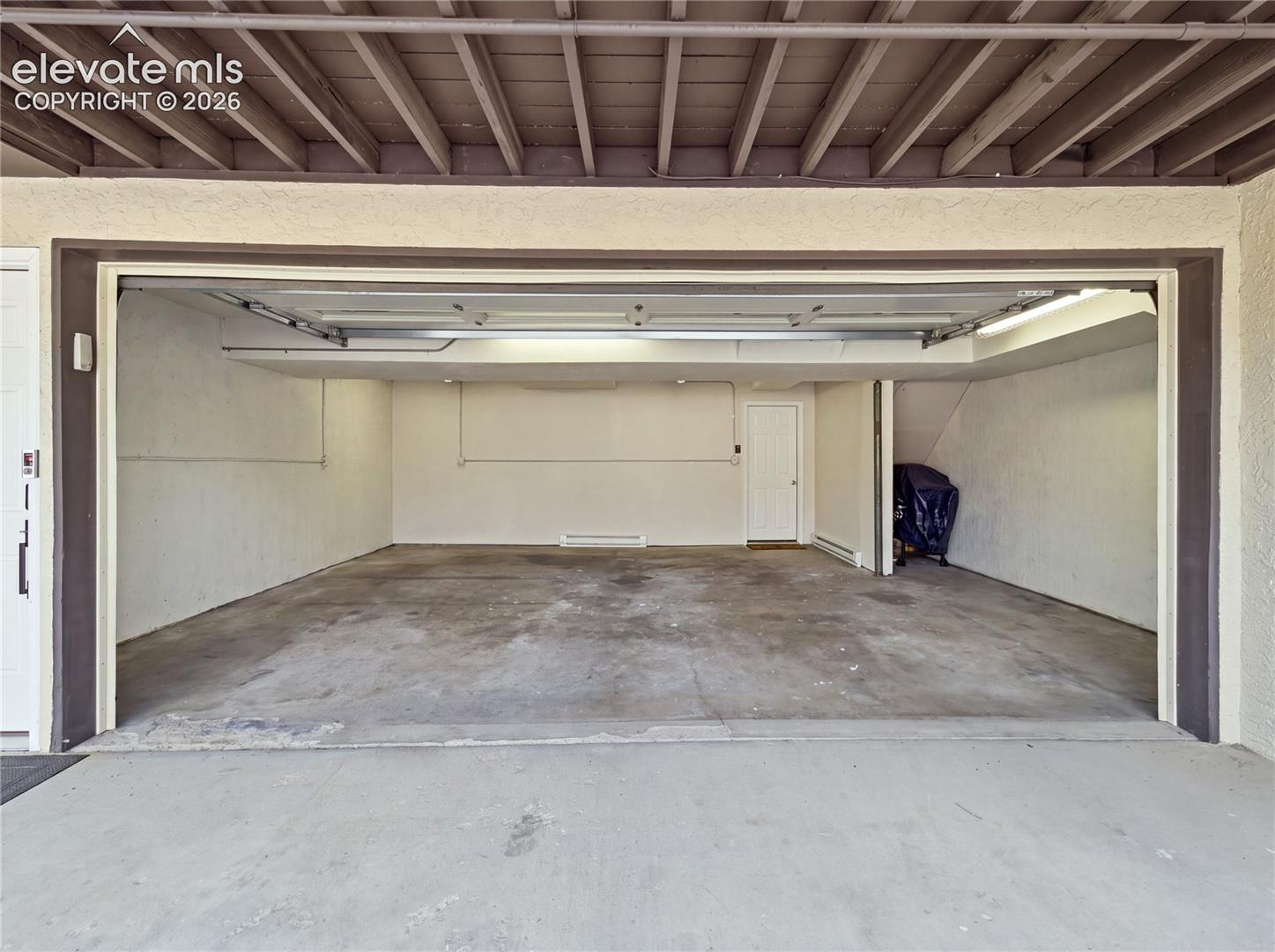 329 Raspberry Lane Monument, CO 80132 - Photo 24 of 25 Attached two-car garage with concrete flooring, finished walls, and a white interior door