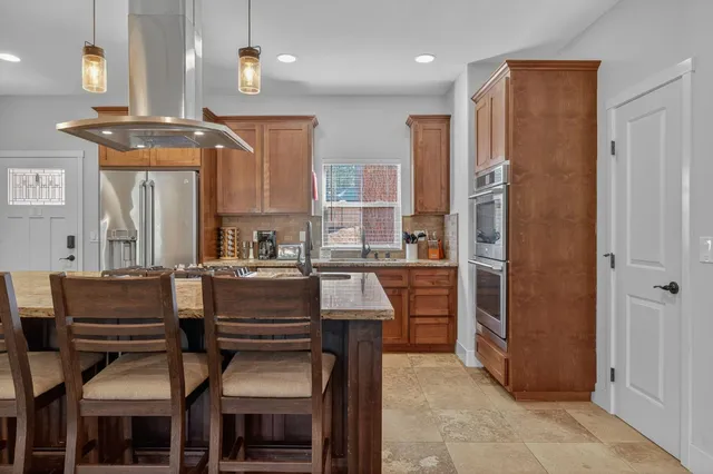 a dining room with wooden floor a chandelier a wooden table and chairs