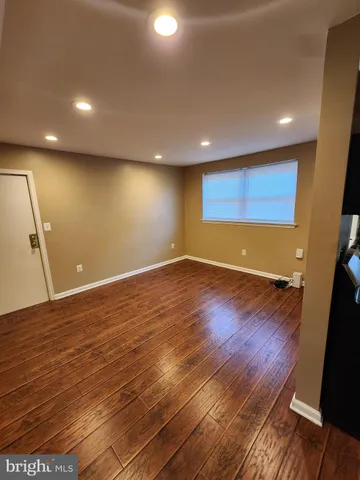 an empty room with wooden floor and entrance