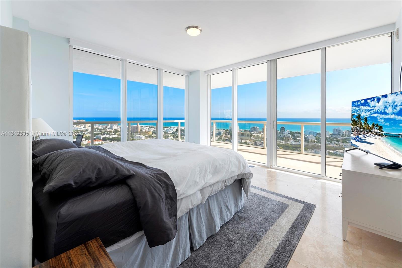 450 Alton Road, Unit 3010 Miami Beach, FL 33139 - Photo 14 of 66 a bedroom with a large bed and a large window