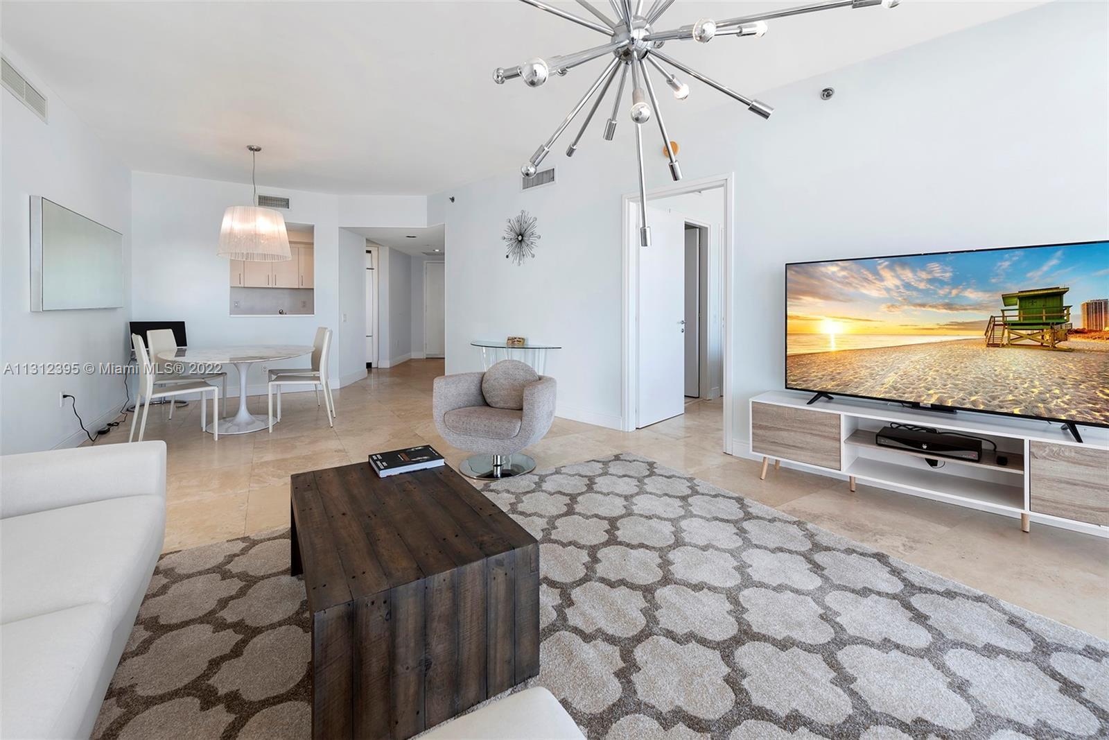 450 Alton Road, Unit 3010 Miami Beach, FL 33139 - Photo 24 of 66 a living room with furniture and a flat screen tv