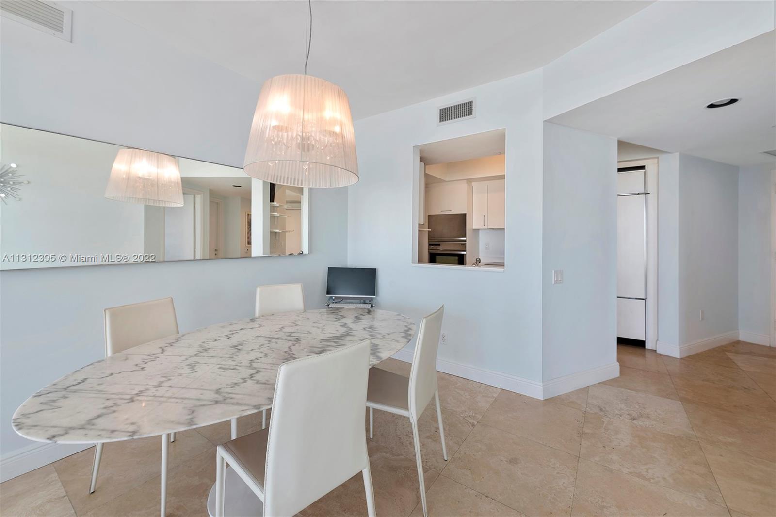 450 Alton Road, Unit 3010 Miami Beach, FL 33139 - Photo 26 of 66 a dining room with furniture and window