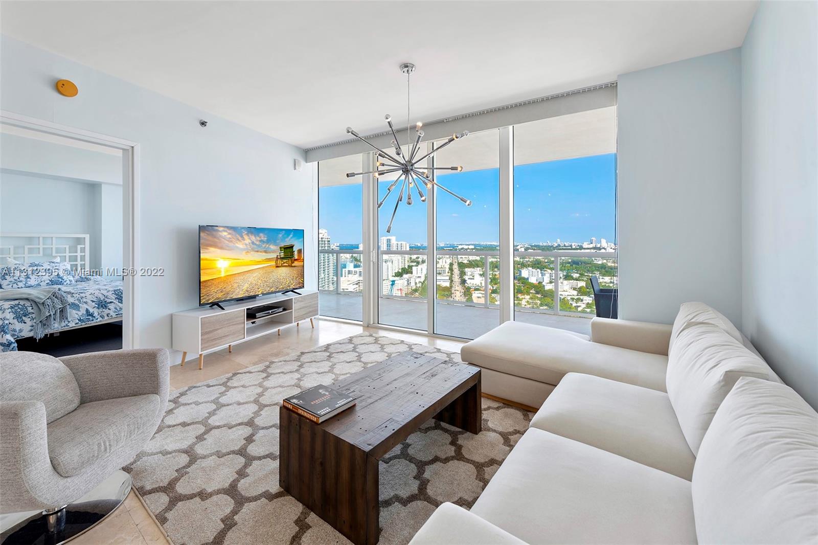 450 Alton Road, Unit 3010 Miami Beach, FL 33139 - Photo 29 of 66 a living room with furniture a dining table and a chandelier