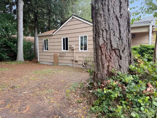 a white house that has a tree in front of it
