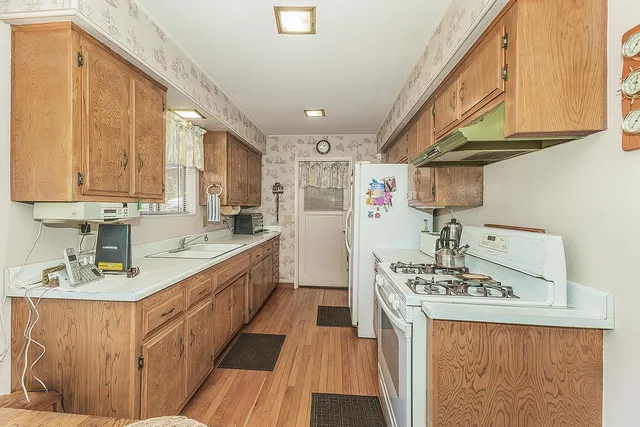 a kitchen with kitchen island granite countertop a sink stainless steel appliances cabinets and a counter top space