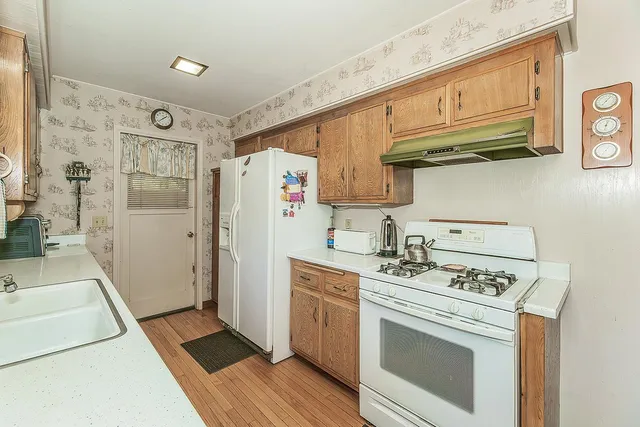 a kitchen with stainless steel appliances a stove a refrigerator and cabinets