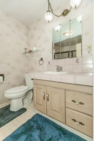 a bathroom with a sink a toilet and mirror