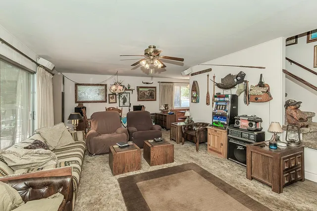 a living room with furniture kitchen view and a window