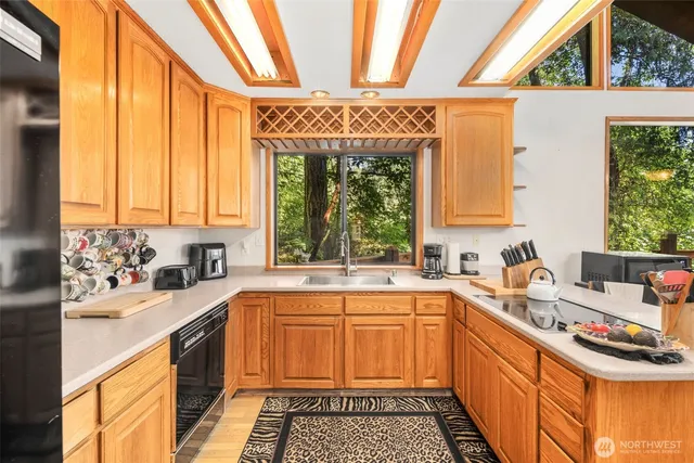 a kitchen with a sink a stove cabinets and a window