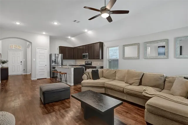 a living room with furniture and kitchen view