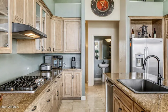 a kitchen with stainless steel appliances granite countertop a sink a stove and cabinets