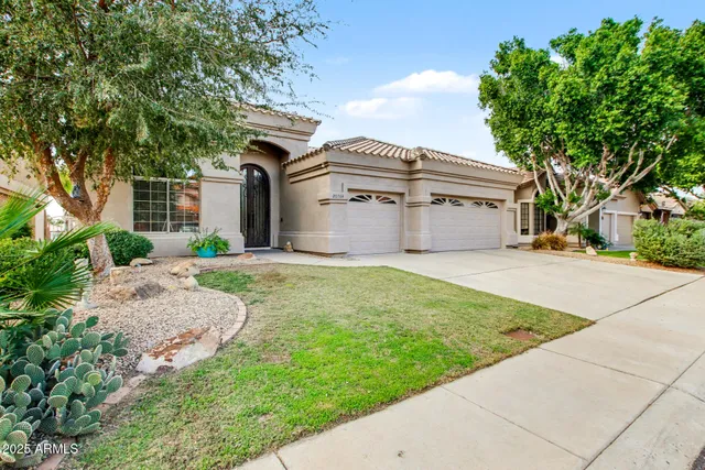 a front view of a house with a garden and yard
