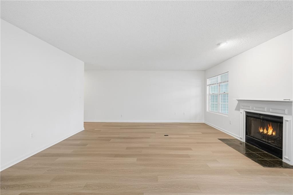 4053 Whitehall Way Alpharetta, GA 30004 - Photo 12 of 28 a view of an empty room with wooden floor fireplace and a window