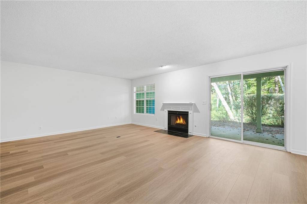 4053 Whitehall Way Alpharetta, GA 30004 - Photo 13 of 28 an empty room with floor to ceiling window and fireplace