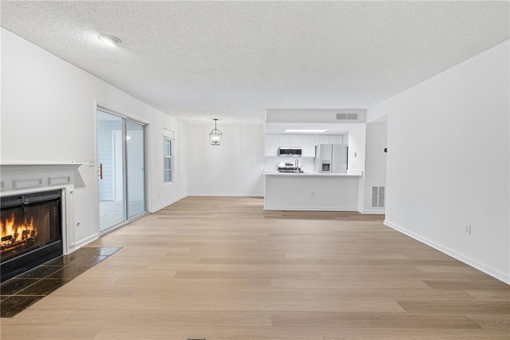 4053 Whitehall Way Alpharetta, GA 30004 - Photo 10 of 28 a view of empty room with a kitchen and fireplace