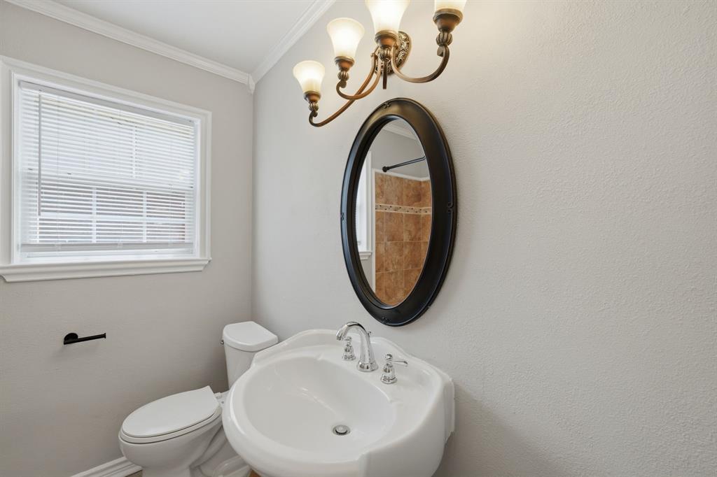 1108 Billie Ruth Lane Hurst, TX 76053 - Photo 20 of 27 Pedestal sink with chrome faucet, framed mirror, and decorative wall sconce lighting
