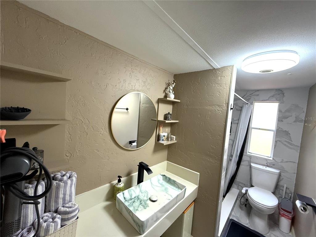 208 Ashley Street Hawthorne, FL 32640 - Photo 14 of 32 a bathroom with a sink mirror vanity and toilet
