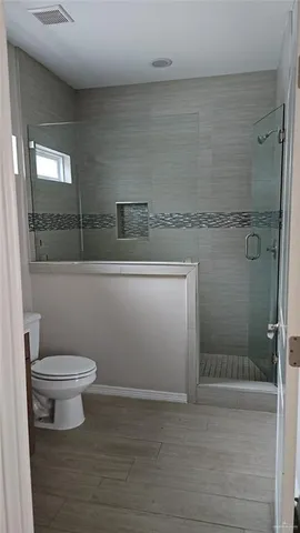 a bathroom with a toilet and a shower
