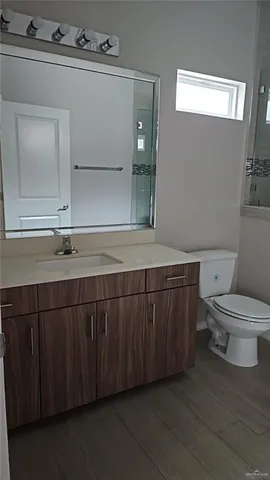 a bathroom with a sink a toilet and mirror