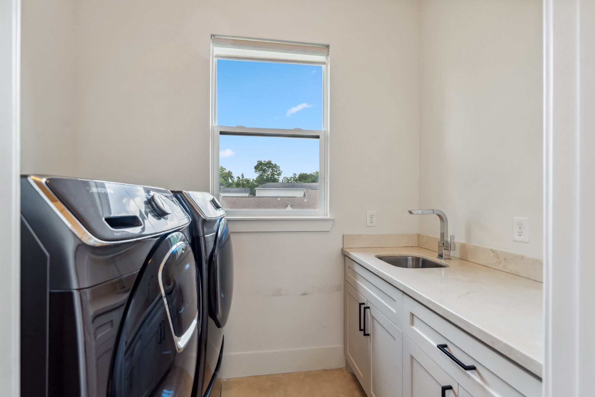 815 East 27th Street Houston, TX 77009 - Photo 32 of 44 Conveniently located upstairs alongside all the bedrooms, this spacious utility room is equipped with a Samsung washer and dryer (included) and hookups for additional appliances if needed. Large cabinets provide ample storage and generous folding space to keep laundry tasks organized. A utility sink adds practicality, while a window with roll-down shades brings in natural light. Just outside in the hall, you’ll find an additional large storage closet for even more organizational options.