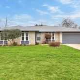 a view of a house with a yard and sitting area