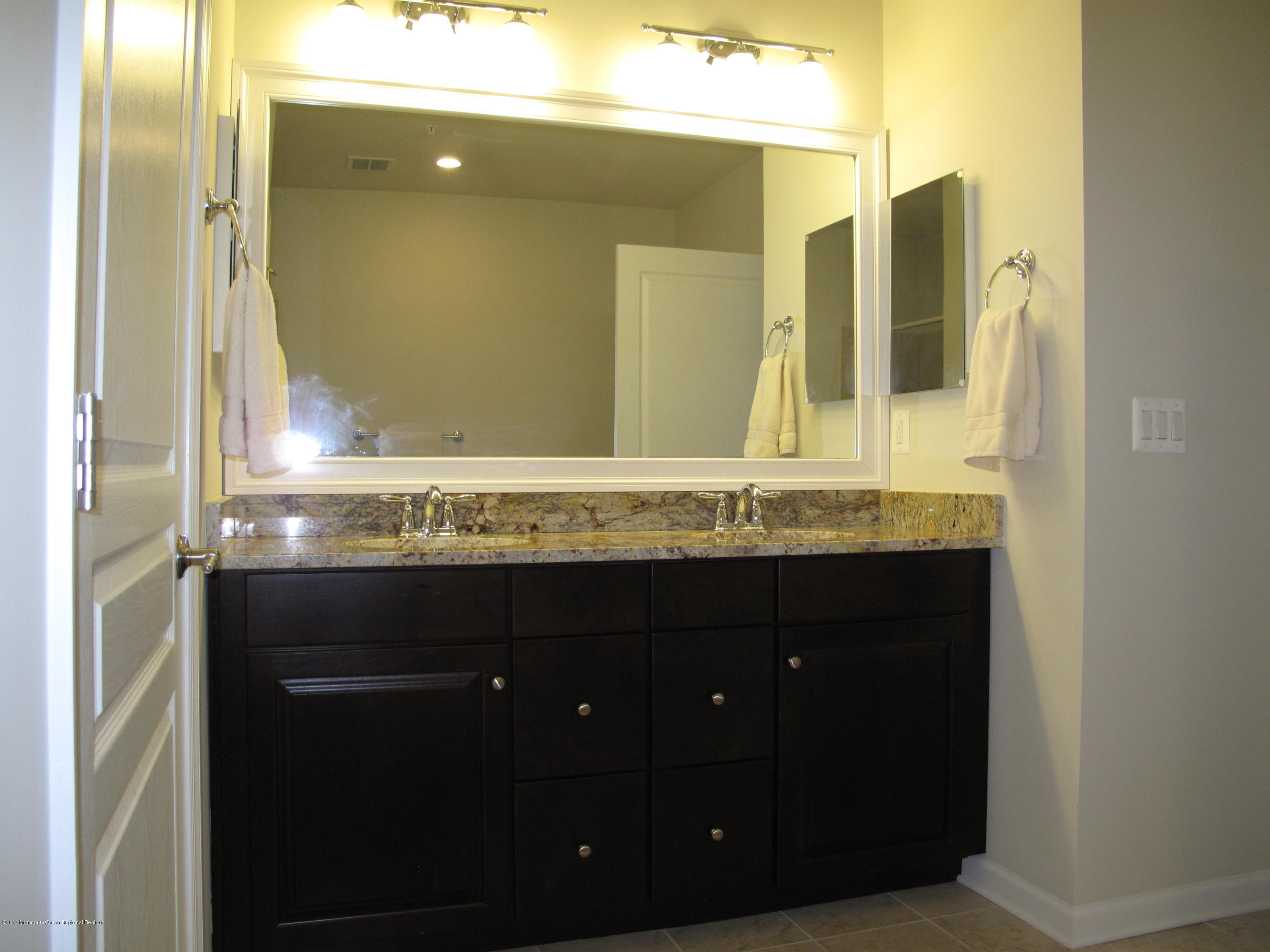 2201 River Road, Unit 4304 Point Pleasant, NJ 08742 - Photo 14 of 30 a bathroom with a granite countertop sink and a mirror