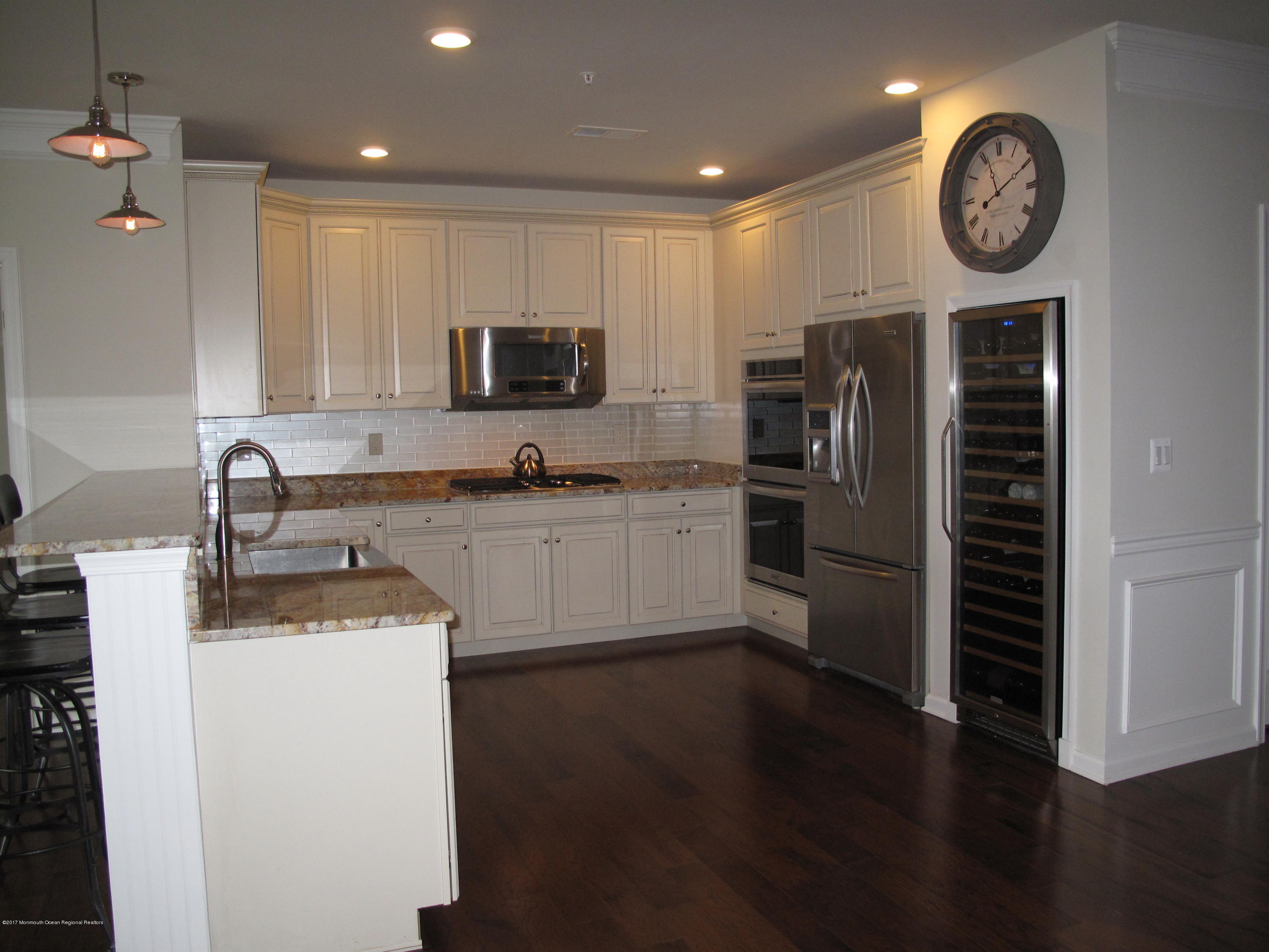 2201 River Road, Unit 4304 Point Pleasant, NJ 08742 - Photo 5 of 30 a kitchen with a refrigerator a sink and a stove top oven with wooden floor