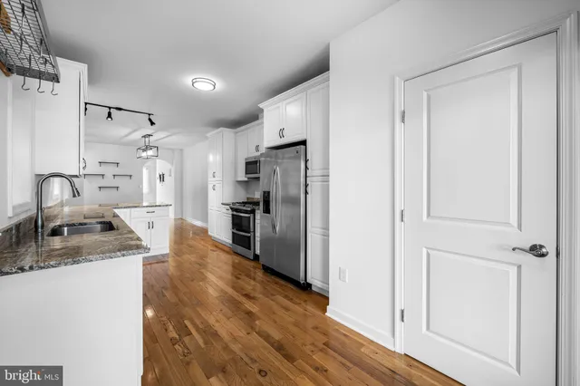 a kitchen with granite countertop a refrigerator and a sink