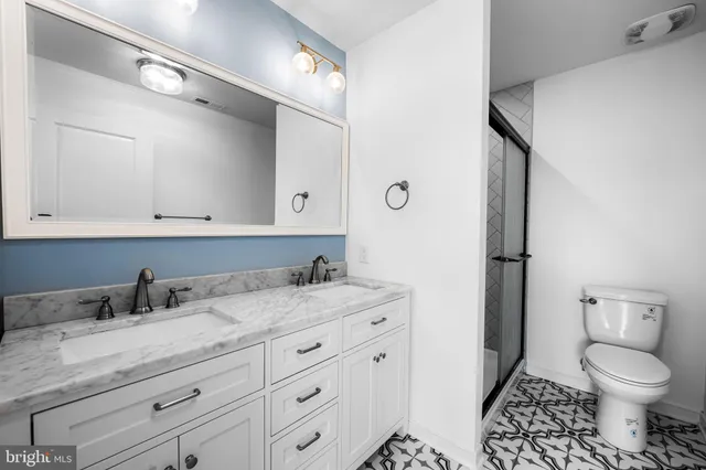 a bathroom with a granite countertop sink a toilet and a mirror