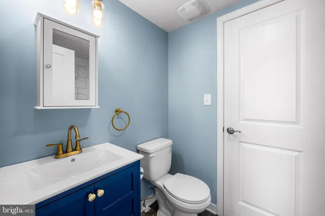 a bathroom with a toilet a sink and mirror
