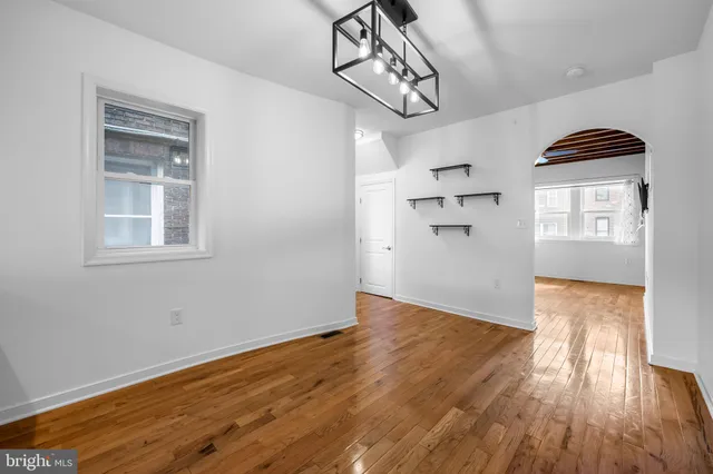 a view of empty room with wooden floor and windows