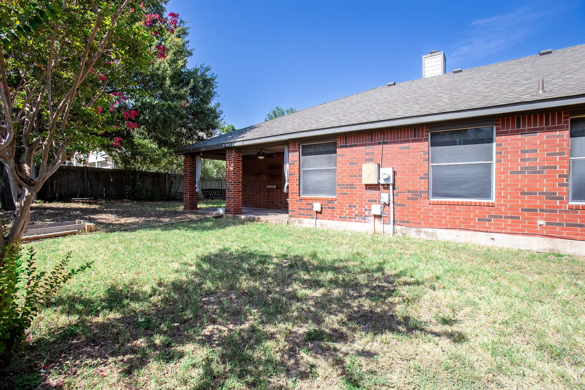 1201 Springbrook Road Pflugerville, TX 78660 - Photo 32 of 33 A private, fenced backyard offers a brick-columned covered patio for outdoor enjoyment.