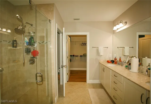 a bathroom with a double vanity sink mirror and shower