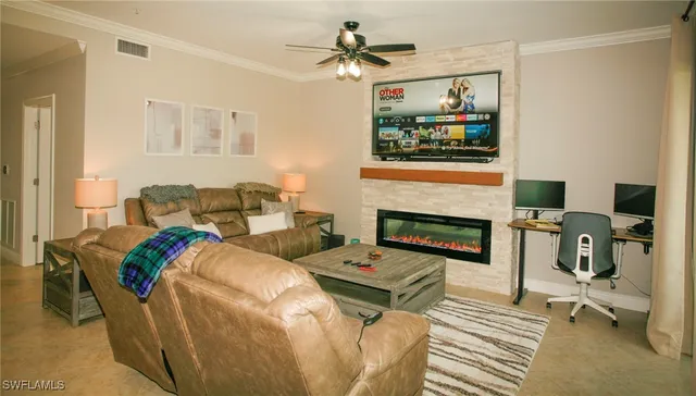 a living room with furniture a flat screen tv and a fireplace
