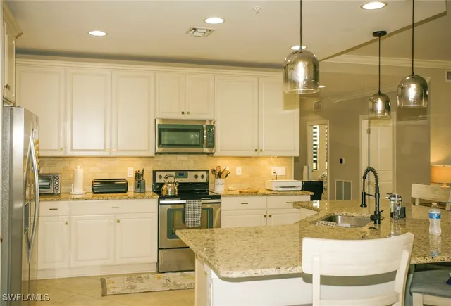a kitchen with stainless steel appliances granite countertop a sink a stove and a refrigerator