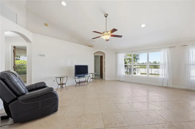 a living room with furniture a flat screen tv and a large window
