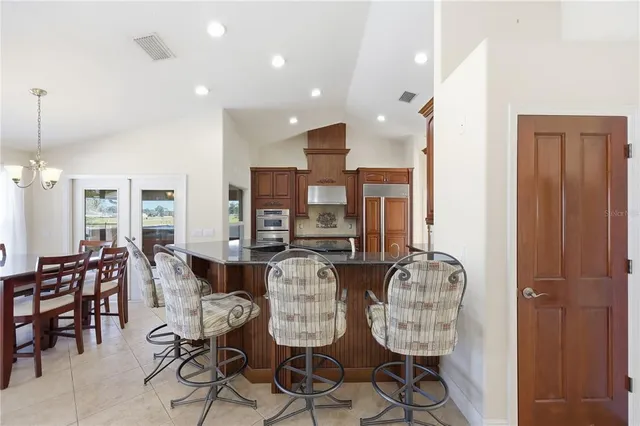 a view of dining room and livingroom with furniture wooden floor a chandelier