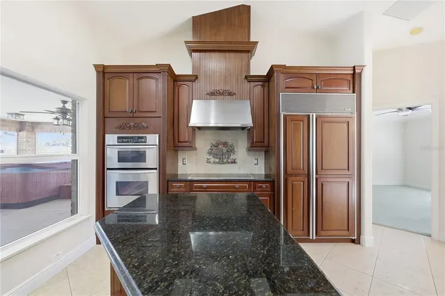 a kitchen with stainless steel appliances granite countertop a refrigerator and a stove