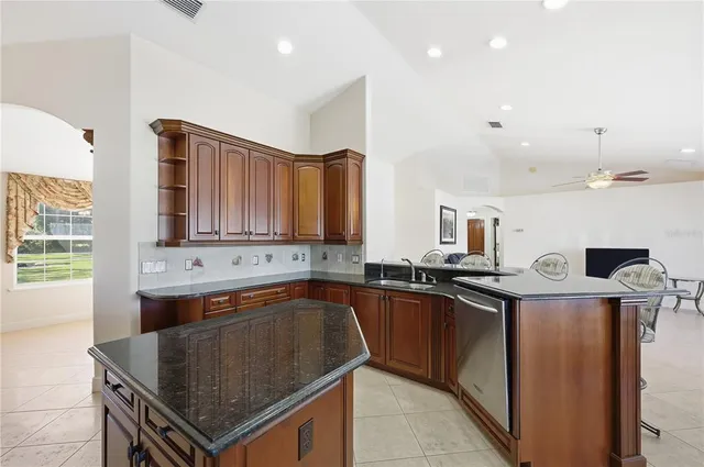 a kitchen with stainless steel appliances granite countertop a sink a stove and a refrigerator