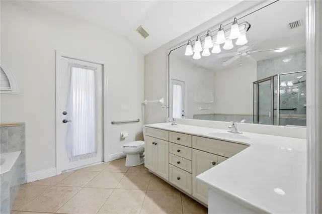 a spacious bathroom with a granite countertop sink a large mirror and a shower
