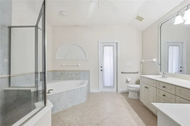 a spacious bathroom with a granite countertop sink a toilet and a bathtub