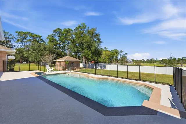 a view of a swimming pool with an outdoor seating and a garden