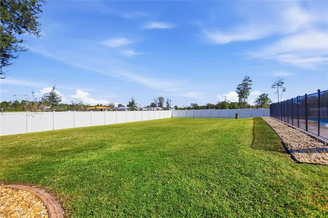 a view of a field of grass and wooden fence