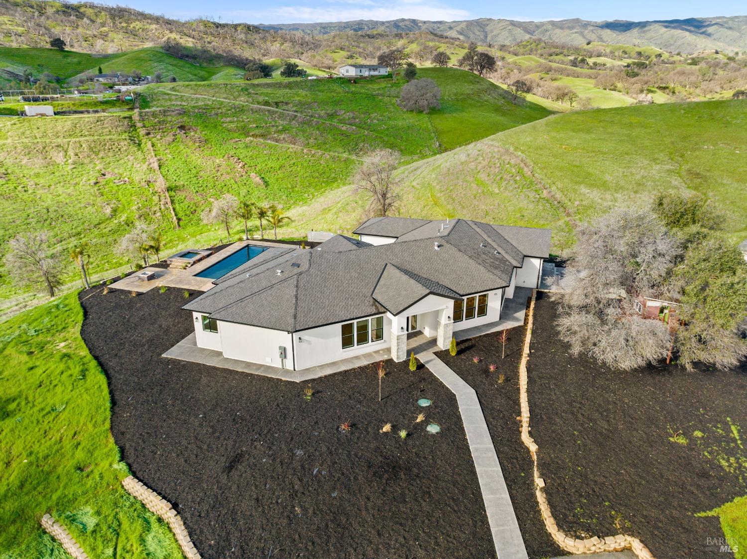 an aerial view of a house with pool lake view and mountain view