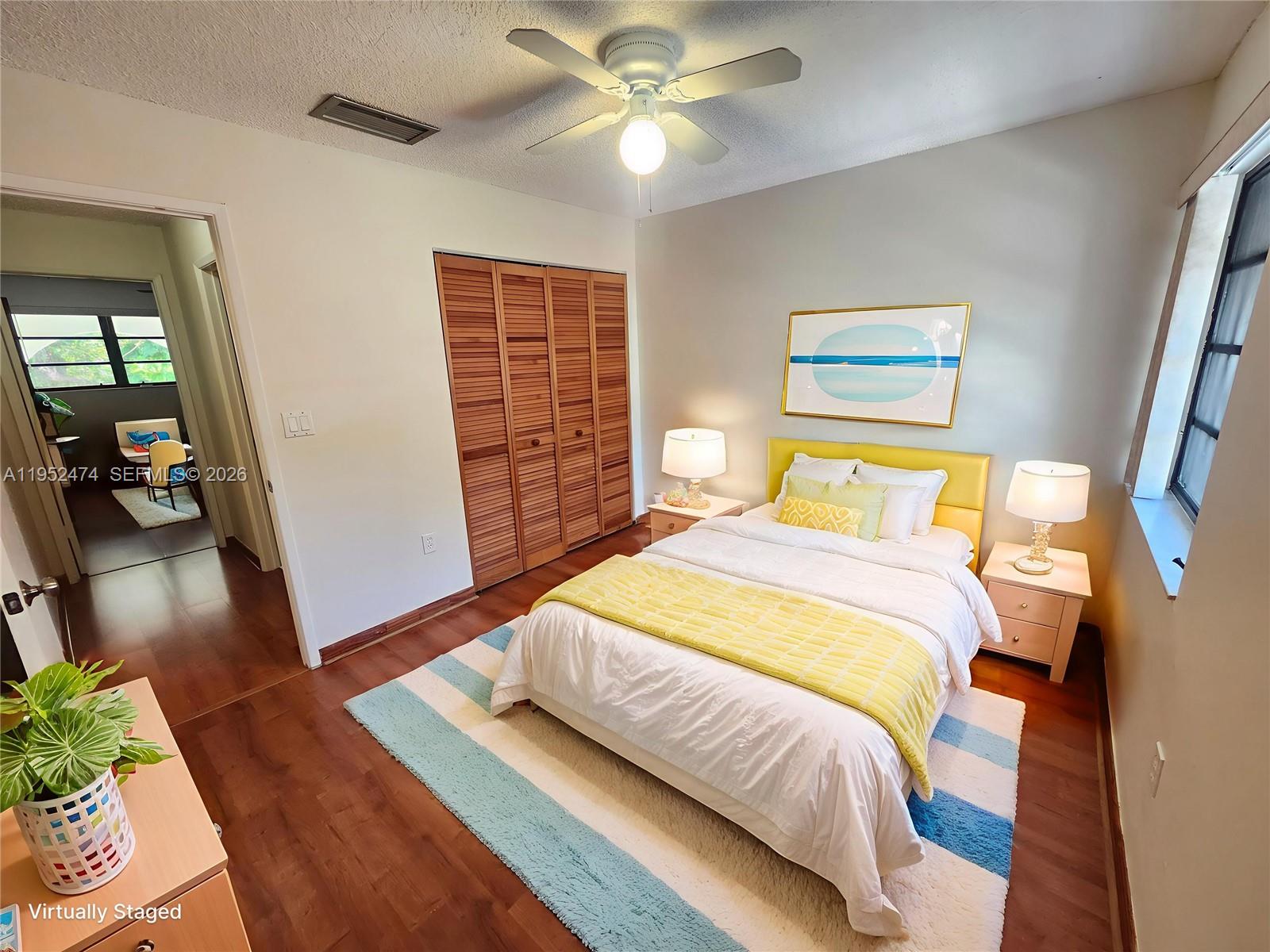 12396 Southwest 94th Lane, Unit 12396 Miami, FL 33186 - Photo 11 of 32 a bedroom with a bed and a chandelier